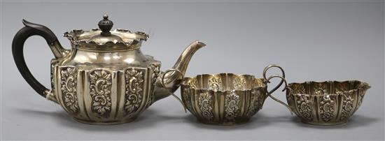 A late Victorian repousse silver three piece tea set, Fenton Brothers Ltd, Sheffield, 1897, gross 15 oz.
